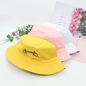 Close-up of three colored cotton bucket hats with 'something' embroidery and decor