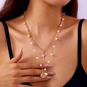 Bohemian double-layer gold necklace with pink starfish and shell pendant worn by model