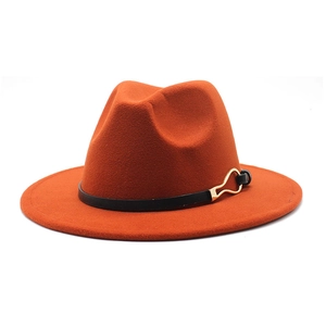 Detail of caramel wool fedora hat featuring a black leather band and gold buckle accent