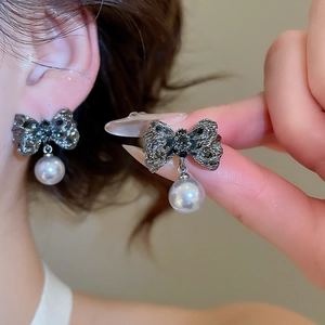 Gros plan détaillé de boucles d'oreilles nœud vintage gris avec perle pendante