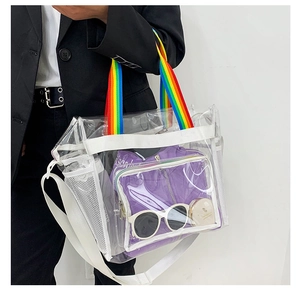 Detailed macro view of large transparent PVC beach bag with rainbow striped handles and strap
