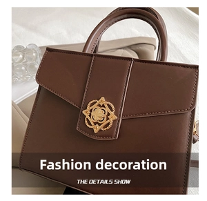 Détail du fermoir floral doré et cuir marron lisse sur un sac à main de luxe