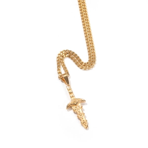 Vue détaillée d'un pendentif épée dorée sur chaîne fine avec texture métallique polie