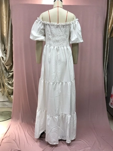 Detail view of the smocked back design and layered tiers on a white off-shoulder dress