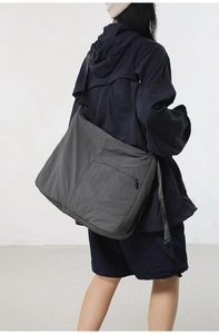 Side view of large charcoal nylon crossbody bag showing spacious capacity and urban style