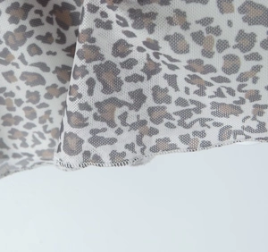 Nahaufnahme des Mesh-Stoffs mit Leopardenmuster und feiner Rollsaum-Stickerei-Detail