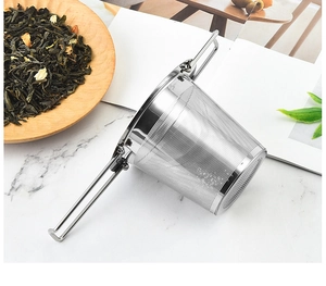 Close-up of a 304 stainless steel tea infuser with dual handles on a marble tabletop