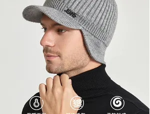 Close-up of gray knit earflap beanie with brim and metal Jeans badge for winter warmth