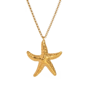Macro view of textured gold starfish pendant and O-chain necklace on white background