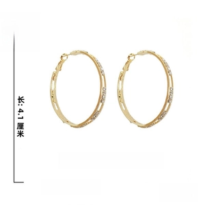 Detail view of large gold hoop earrings with pavé rhinestones and 925 silver posts