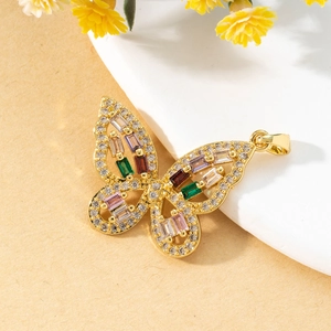 Macro detail of a gold butterfly pendant with colorful gemstones and zircon inlay
