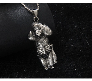 Macro shot of silver poodle pendant with polka dot shorts on dark textured background