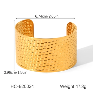 Macro shot of gold wide cuff bracelet with woven texture and product dimensions