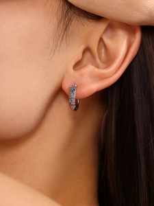 Detail of silver hoop earrings featuring rainbow cubic zirconia and turquoise stones