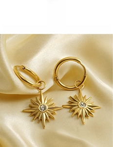 Macro view of 18K gold titanium steel sunflower hoop earrings with zircon on silk