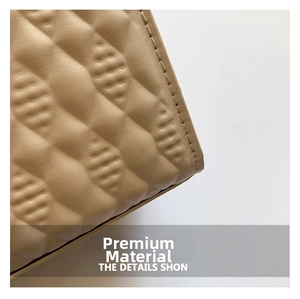 Detail of light brown leather crossbody bag with wavy quilted texture and stitching