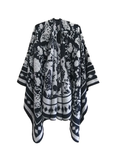 Detail view of the intricate knit pattern featuring floral and butterfly motifs on a shawl