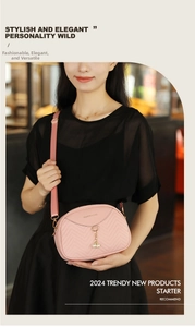 Pink quilted crossbody bag detail with pearl pendant and adjustable strap on a black outfit