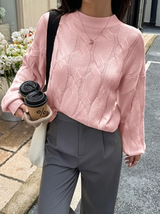 Close-up of pink cable knit sweater with half-high collar and long sleeves for winter