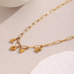 Close-up of 18K gold plated paperclip chain necklace with LOVE letter pendants