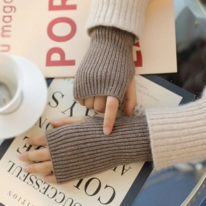 Close-up of dark coffee knit fingerless gloves with ribbed texture on a warm desk