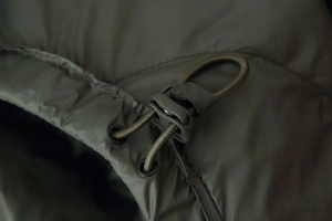 Detail of adjustable elastic drawstring and plastic buckle on olive green hooded parka