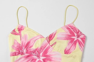Detailed view of yellow V-neck dress featuring pink lily prints and spaghetti straps
