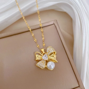 Macro shot of titanium bow necklace with shimmering rhinestones and a white pearl drop