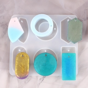 Macro view of geometric silicone resin mold and finished glitter jewelry pendants