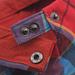 Macro shot of colorful plaid fabric with metallic star-patterned snap buttons on the hat