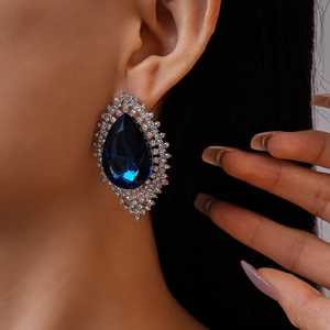 Close-up of oversized teardrop blue crystal earring with shimmering rhinestone details