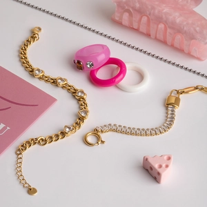 Detailed view of 18K gold plated chain bracelet with heart zircon and pink resin ring