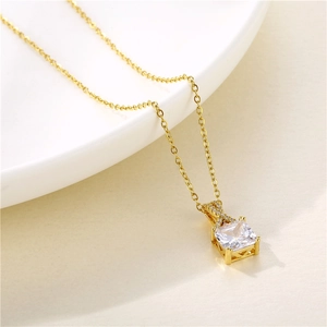 Minimalistische quadratische Zirkon-Halskette mit Goldkette auf weißem Keramiktablett