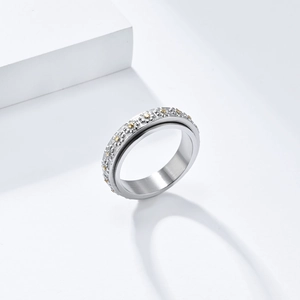 Detailed view of rotating daisy ring showing relief flowers and brushed metal texture
