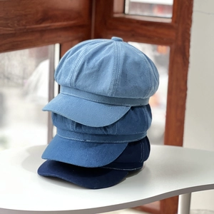 Three denim newsboy caps in light, medium and dark blue showing fabric texture and layers