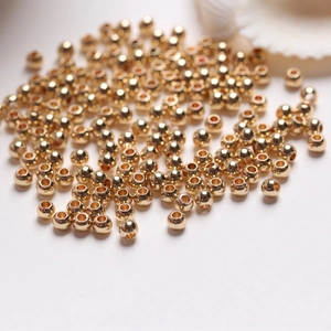 Macro shot of 14k gold-filled round beads with center holes for DIY jewelry making