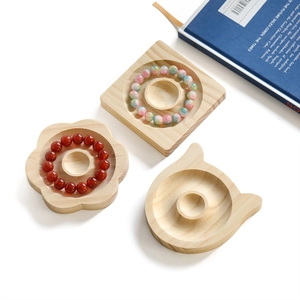 Detailed view of three-piece wooden jewelry display trays in flower, square and bird shapes