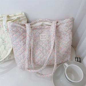 Détail du sac cabas en coton matelassé avec des motifs floraux et une texture douce