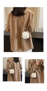 Détail du mini sac bandoulière blanc matelassé avec poignée dorée et chaîne sur un modèle