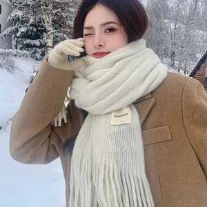 Set sciarpa e guanti in maglia bianca per donna in una foresta innevata invernale