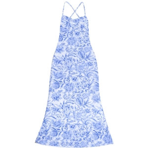 Détail des bretelles croisées et imprimé floral bleu sur une robe d'été longue blanche