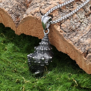 Retro conch shell stainless steel pendant on box chain over rustic moss and bark