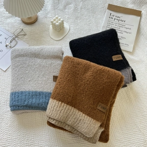 Close-up of knit scarves showing plush cashmere texture and sewn FUNFU leather brand tags