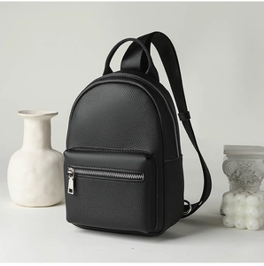 Close-up of black litchi pattern leather and silver zipper on mini crossbody chest bag