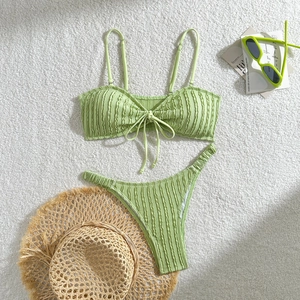 Detailierte Flachbild-Ansicht des hellgrünen strukturierten Bikinis mit sommerlichen Accessoires