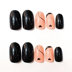 Detailed view of oval press-on nails with black glossy finish and heart line art patterns