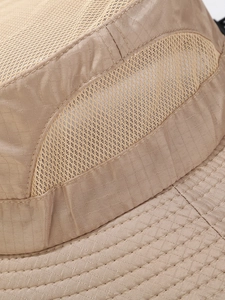 Macro detail of khaki outdoor hat showing ripstop fabric and breathable mesh vents
