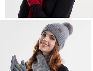 Detailed knit texture of grey winter hat scarf and gloves set with soft faux fur pom-pom