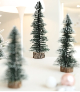 Macro detail of mini snowy Christmas tree with green sisal needles and wooden base