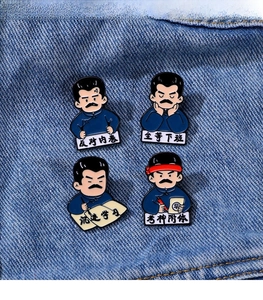 Detailed view of four Lu Xun cartoon enamel pins with Chinese text on denim background